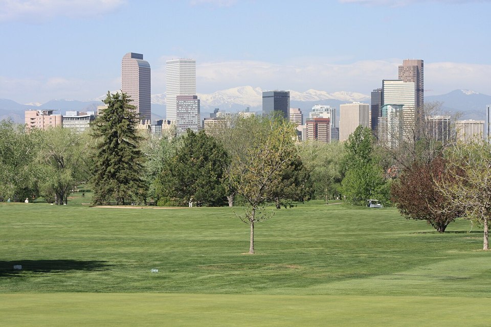 Denver skyline and distant mountains seen across City Park Golf Course